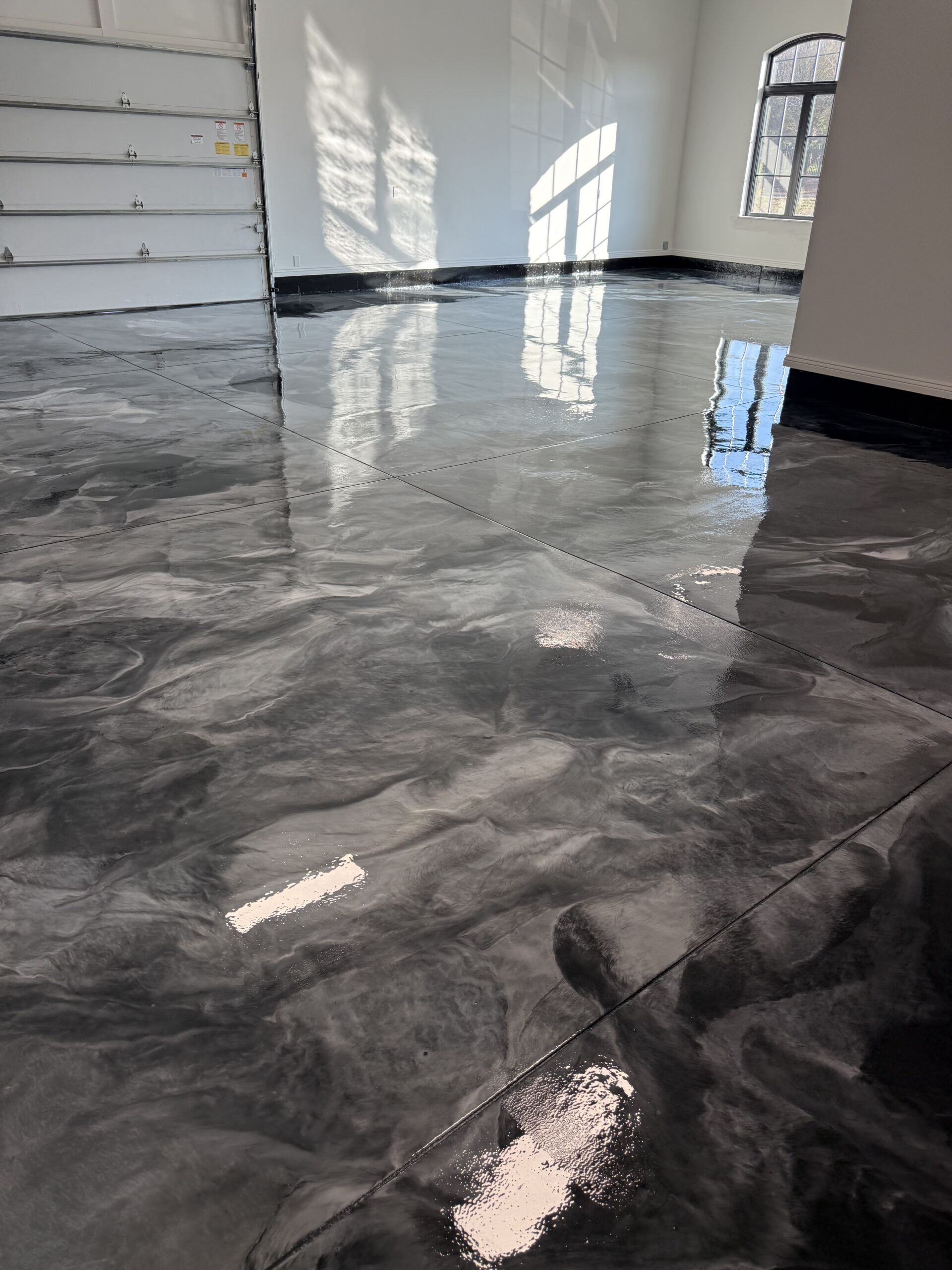 Metallic epoxy commercial floor with dark grey marbled finish