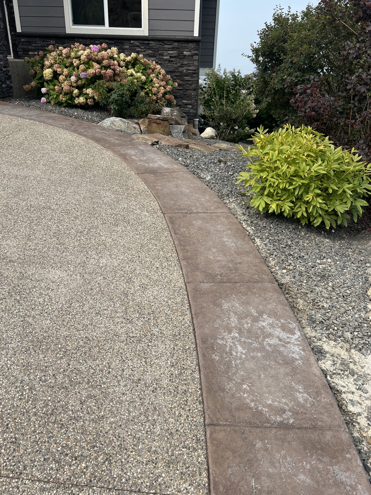Worn stamped concrete border before driveway recolouring